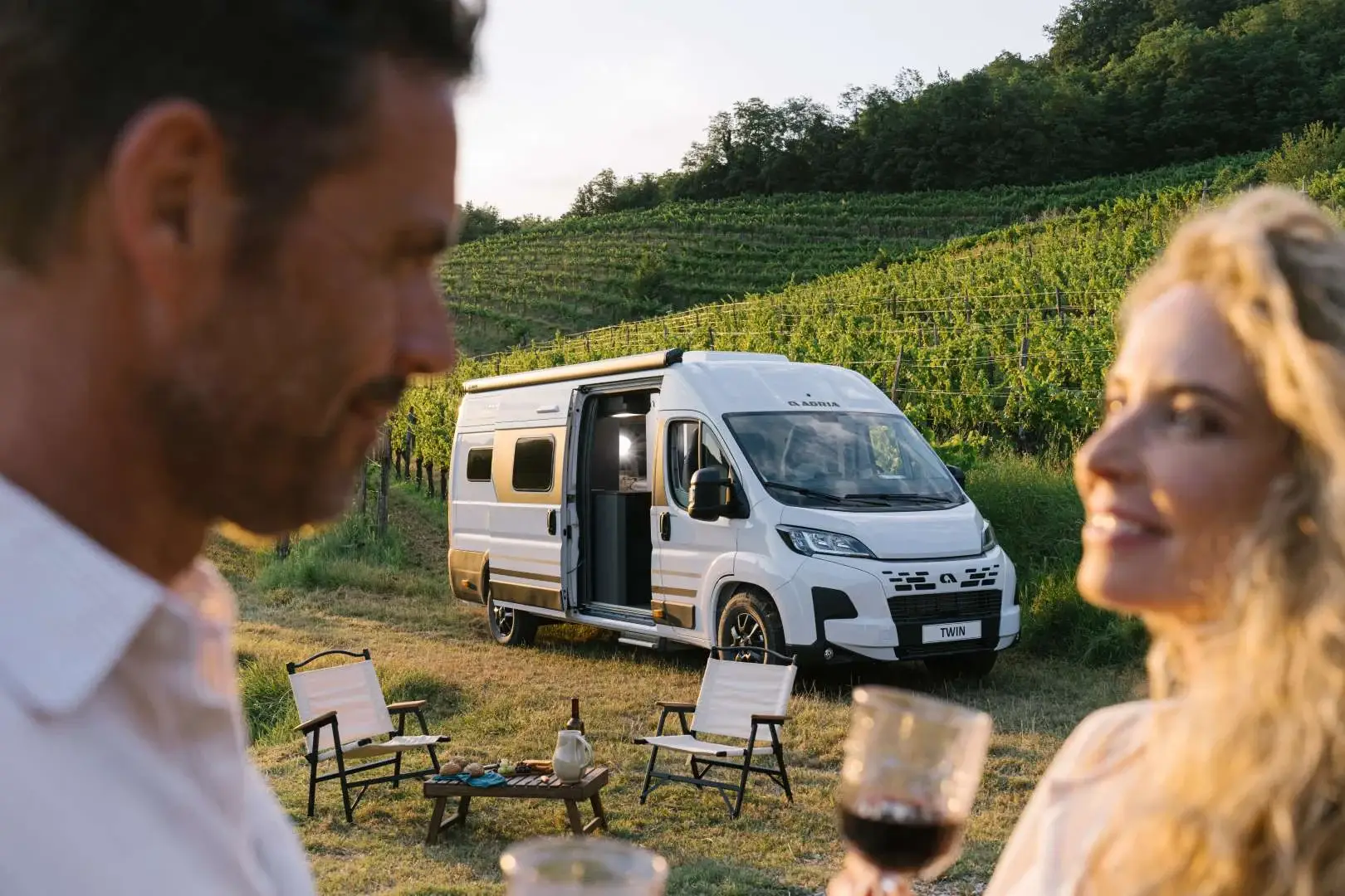 Paar vor einem Adria Twin Campervan